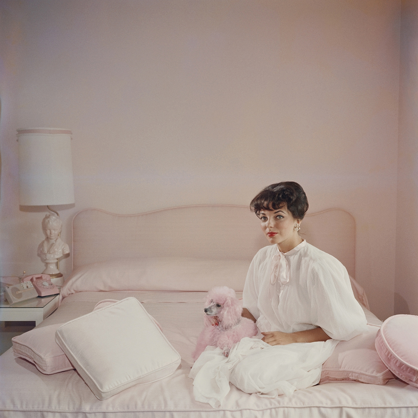 Who wouldn't want this framed Slim Aarons photograph of Joan Collins in a pink and white bedroom with a pink poodle, circa 1955, on their wall? $1,450 @jonathanadler.com